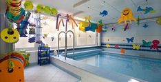 an indoor swimming pool with toys hanging from the ceiling