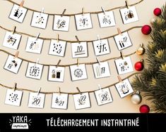 a christmas tree is next to a string with greeting cards on it that spell out the word,'telegrement instantane '