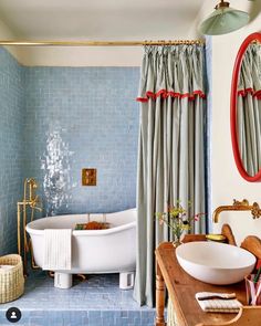 a bath room with a tub a sink and a mirror on the wall next to a table