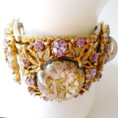 Selro Violet Rhinestone Pink Glitter Bracelet, Book Piece Selro Vintage Link Bracelet, Selro Art Nouveau Rhinestone Gold Bracelet Selro bracelet featuring high-domed lucite cabochons filled with pink confetti on gold glitter. Coordinating lavender rhinestones in heavy antiqued gold-tone setting with intricate floral motif. The reverse side has quality riveted framework. Unmarked but appears in Warman's Costume Jewelry, page 249. Measures 7 1/4 " X 1 1/2". Matching pendant necklace: https://www.e Vintage Adjustable Crystal Bracelet For Party, Costume Jewelry Crystal Jeweled Bracelets, Gold Crystal Party Bracelet With Stones, Gold Crystal Bracelet For Party, Gold Crystal Bracelet With Stones For Party, Vintage Jeweled Crystal Bracelet Gift, Vintage Jeweled Crystal Bracelet For Gift, Costume Crystal Bracelet With Rhinestones For Gift, Gift Rhinestone Crystal Costume Bracelet