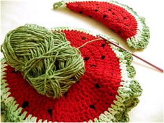 watermelon crocheted dishcloth with yarn and knitting needles