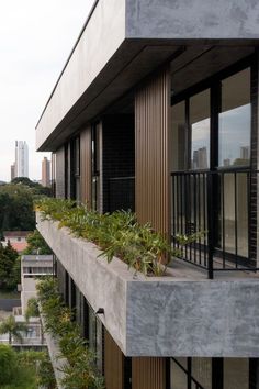 an apartment building with plants growing on the balconies