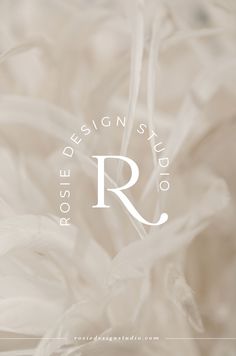 the logo for rose design studio, which is located in front of some white feathers