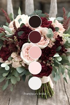 a bridal bouquet with red and pink flowers, greenery and foliage on an old wooden table