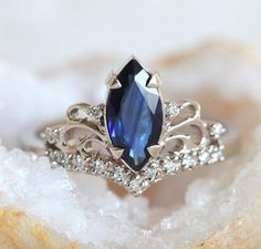 a close up of a ring with a blue stone in it on top of some crystals