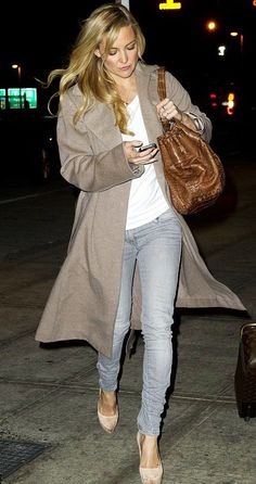 a woman is walking down the street with her luggage