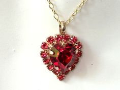 Elegant Red Crystal Heart Crystal Necklace Surrounded with 15 small Light Red (Light Siam) Crystals.  Set in a gold plated prong setting. I used a  11x10mm crystal heart in Siam Red Heart. Please choose the size of the chain you prefer in : 16 to 20 inches. The pendant is 1 inches from the top of bail - see 2nd picture for size. ArtistInJewelry on Etsy offers Fine Crystals - Vintage Czech - Germany and Japanese Rhinestones and Glass to create my pieces. My Handmade Jewelry is inspired by Art Dec Red Heart Cut Necklace For Wedding, Red Heart Necklace For Valentine's Day Party, Red Heart Cut Necklace For Party, Red Double Heart Necklace For Wedding, Wedding Double Heart Red Necklace, Wedding Red Double Heart Necklace, Heart Necklace Gold, Red Heart Necklace, Crystal Heart Necklace