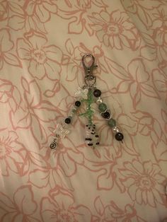 a pair of scissors is laying on a floral print sheet with beads and stones in the shape of a tree