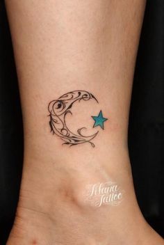 a small tattoo on the foot of a woman with a crescent and star in it