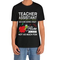 a man wearing a teacher assistant t - shirt with an apple on the front and back