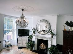 a living room filled with furniture and a fire place under a large mirror on the wall