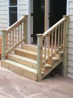 a wooden porch with steps leading up to the front door