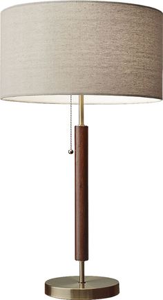 a table lamp with a wooden base and beige shade on the top, sitting on a white background