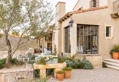 an outside view of a house with potted plants