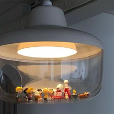 a group of figurines sitting on top of a shelf under a light fixture