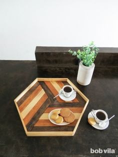 there is a small tray with cookies on it and two cups of coffee next to it