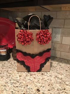 a brown paper bag with red bows on it sitting on top of a kitchen counter