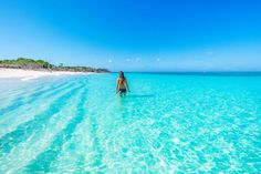 a woman is standing in the clear blue water