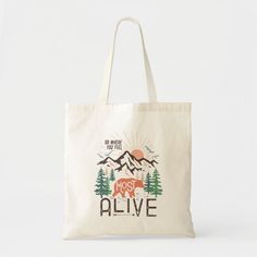 a tote bag with an image of a bear and mountains in the background that says, most alive