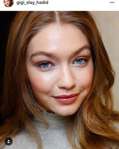 a woman with long brown hair and blue eyes