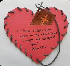 a paper heart with a cross on it and a bible verse written in the middle