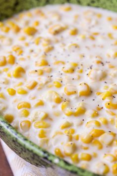 a bowl filled with corn on top of a table