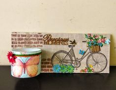 a coffee cup sitting on top of a table next to a sign with flowers and a bicycle