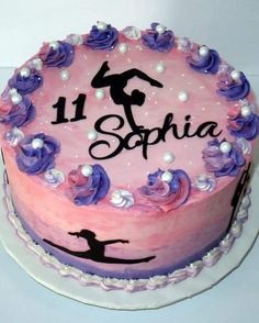 a pink and purple birthday cake with the number 11 on it, decorated with flowers