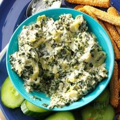 a blue plate topped with cucumbers and dip