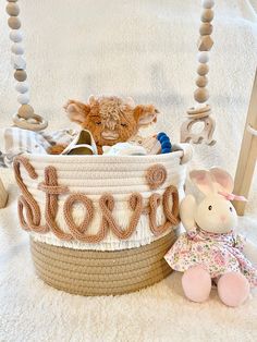 a teddy bear sitting next to a basket with the word love spelled out on it