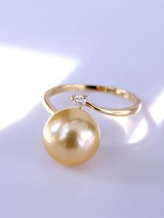 * Condition: Brand new * Center Stone: Natural Golden South Sea Pearl 10-11mm * Pearl Shape Grade: Perfectly Round * Side Stone: Natural White Diamond, Round Cut, approx 0.05ct (VVS clarity with F color)  * Metal Purity: 18K Solid Yellow Gold (optional) * Superior pearls standard - 99% of the pearl surface is clean. An extremely detailed and up-close study of the pearl is needed to find imperfections. * The item will be gift wrapped and shipped. ------------------AUTHENTICITY------------------ A Luxury Yellow Gold Ring With Tahitian Pearl, Luxury Everyday Yellow Gold Pearl Ring, Elegant Yellow Rings With Diamond Accents, Luxury Polished Pearl Ring, Elegant Yellow Diamond Ring With Brilliant Cut, Elegant Yellow Diamond Ring For Anniversary, Luxury Yellow Gold Open Pearl Ring, Luxury Brilliant Cut Pearl Ring, Elegant 14k Gold Yellow Diamond Ring