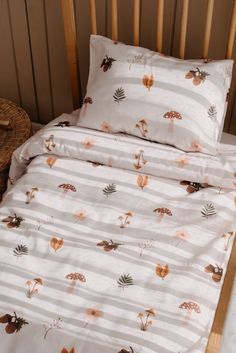 a bed with white sheets and brown leaves on it