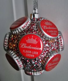 a red and silver bottle cap ornament hanging from a hook on a door