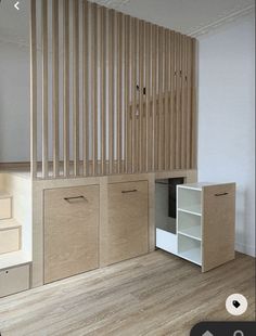 an empty room with some cabinets and shelves on the wall, next to stairs that are made out of plywood