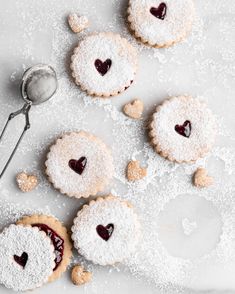 several cookies with hearts on them and powdered sugar in the middle one cookie has been cut into pieces