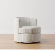 a white chair sitting on top of a hard wood floor next to a white wall