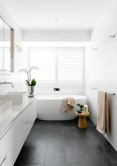 a white bath tub sitting in a bathroom next to a sink