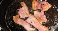 bacon is cooking in a skillet on top of the stove with water and oil