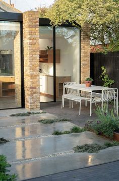 an outdoor dining area with white chairs and table