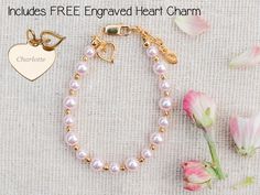 Personalized with FREE engraved heart charm this timeless bracelet is made with pink high-end simulated Austrian pearls and 14K Gold-plated beads (over sterling silver) accented with a beautiful dainty accent heart embellished with sparkling CZs!  This trendy high quality bracelet is available in three sizes for infants, babies, toddlers, and kids.  This bracelet makes a sweet Valentines gift, baby gift, or something special for your granddaughter and comes in a beautiful gift box ready for gift Customizable Pink Charm Bracelet As Gift, Pink Heart Bracelet For Valentine's Day Anniversary, Personalized Pink Charm Bracelet For Mother's Day, Pink Heart Charm Bracelet For Anniversary, Customizable Pink Charm Bracelet For Personalized Gift, Personalized Pink Jewelry For Keepsake, Pink Bracelets For Anniversary On Valentine's Day, Pink Name Jewelry For Mother's Day, Pink Bracelets For Anniversary And Valentine's Day