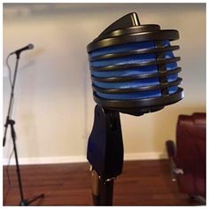 a blue and black lamp sitting on top of a wooden floor next to a microphone