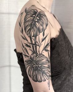 a black and white photo of a woman's arm with flowers on it