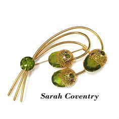 "*Description: This is a beautiful Sarah Coventry brooch entitled \"Touch of Elegance\" which has three green Austrian crystal faceted oval stones with gold tone filigree flower tops from the 1970s. Each flower top has a green rhinestone chaton with a larger green rhinestone chaton placed on the stems. This brooch is a book piece and is found on page 100 of Sarah Coventry Jewelry by Kay Oshel. The brooch is also featured in The Art of Juliana Jewelry by Katerina Musetti. This would be a great ad Mid-century Green Brooch For Formal Occasions, Mid-century Green Brooches For Formal Occasions, Antique Green Brooch For Anniversary, Antique Green Brooches For Anniversary, Green Mid-century Style Brooches For Formal Occasions, Mid-century Green Formal Brooches, Mid-century Green Brooch As A Gift, Juliana Jewelry, Formal Earrings