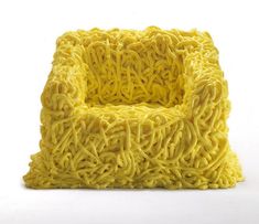 a yellow chair made out of noodles on a white background