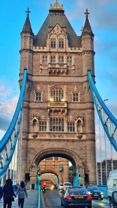 the tower bridge is very tall and has cars on it