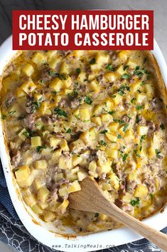 cheesy hamburger potato casserole in a white dish with a wooden spoon