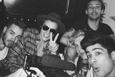 black and white photograph of group of young men with one man holding up the peace sign