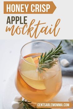 honey crisp apple mulled in a glass with rosemary garnish on the rim