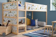 a child's bedroom with blue walls and wooden bunk beds, toys and rugs