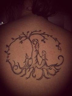 the back of a woman's shoulder with a tree and two people on it